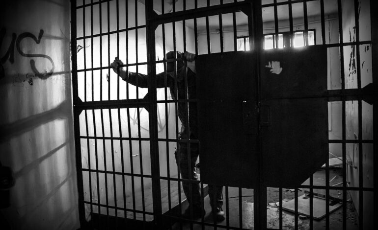 A protest sign advocating for the repeal of blasphemy laws in Islamic countries, with a diverse crowd in the background.