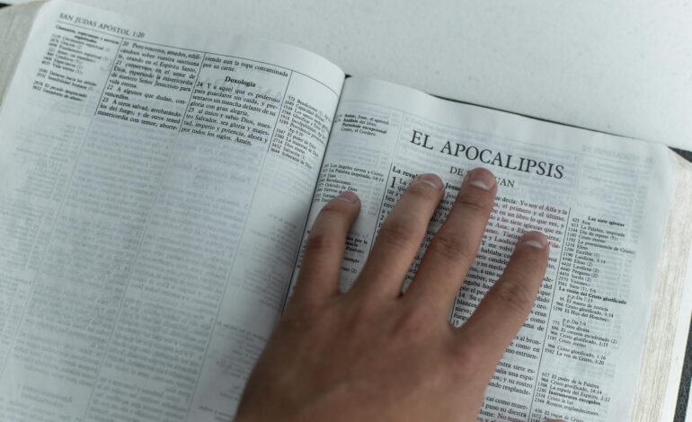 Ancient religious texts on wooden table with magnifying glass, representing logical analysis of sacred writings